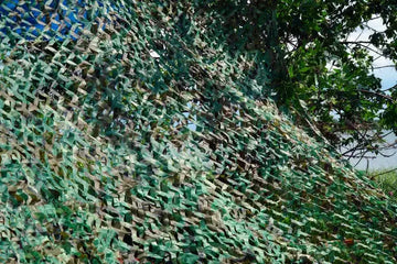 Military green camouflage netting masking and covering a secret object