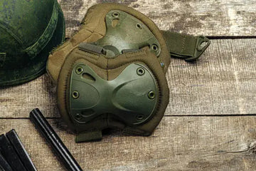 Military knee pads on wooden surface