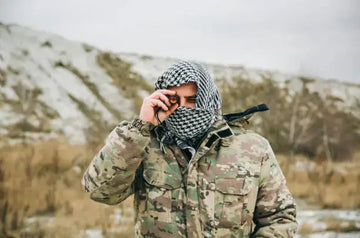 Soldier in a camouflage uniform and a checkered keffiyeh shemagh bandana.