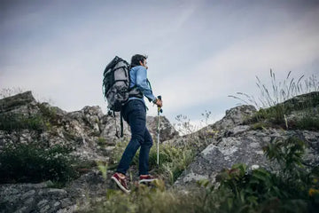 Young man hiking with a backpack on the mountain