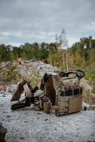 tactical vest with pouches placed on a rocky surface in an outdoor setting